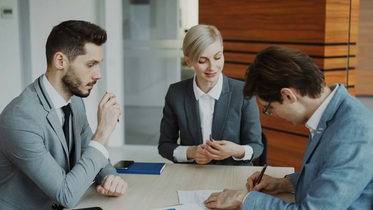 Legal professionals reviewing and signing documents with a client